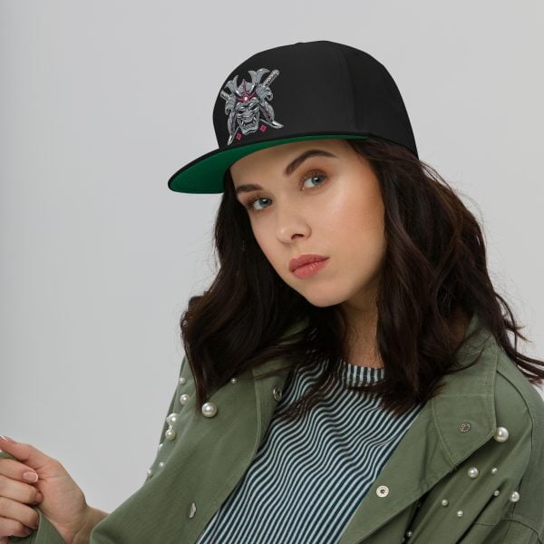 A woman donning a trendy black and green Toyota Supra MKIV "The Samurai" snapback hat with a flat bill cap design.