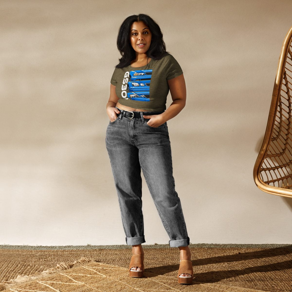 A woman wearing jeans and a Lexus GS300 JZS161 Generations Women's Crop Tee standing in front of a rug.