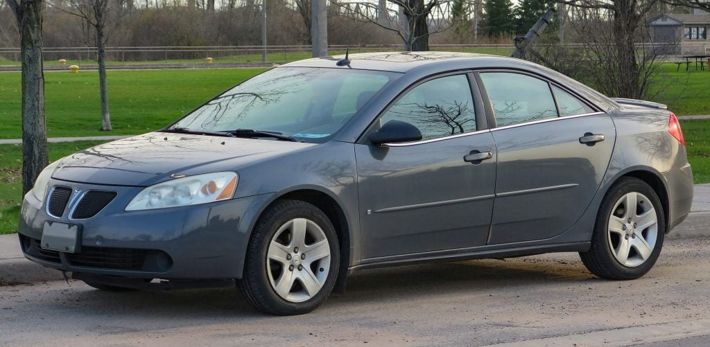 A gray Pontiac G6 is parked on the side of the road.
